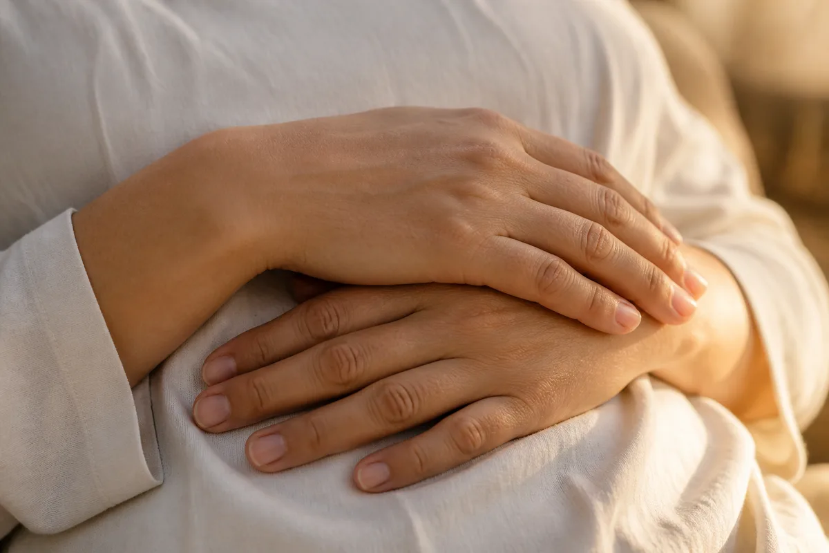 Mains posées sur le ventre pendant un exercice de respiration abdominale, lumière douce